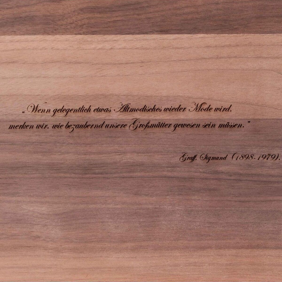 Ein ZEIT-Accessoire-Set mit einer Holzplatte und einem eingravierten Zitat von Gustav Klimt (1862-1918). Die Platte zeigt eine natürliche Holzmaserung in Brauntönen und Beige, mit einem dezenten, handgefertigten Design. Eignet sich ideal als dekoratives Element oder Geschenk für verschiedene Anlässe.
