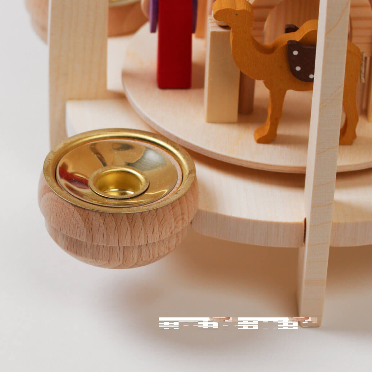 Eine Weihnachtspyramide »Christgeburt« aus Holz, die für Teelicht und Pyramidenkerzen geeignet ist. Die Pyramide zeigt eine Szene der Christgeburt mit handgeschnitzten Figuren, darunter ein Kamel. Die Farbgebung umfasst natürliche Holzfarben, Akzente in Gold, Weiß und Rot.