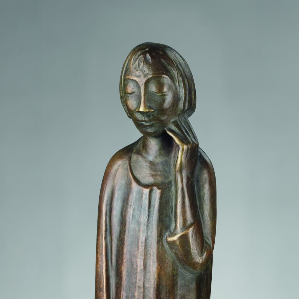 Bronze-Skulptur von Ernst Barlach mit dem Titel 'Der Sinnende II' aus dem Jahr 1934, zeigt einen nachdenklichen Menschen mit geschlossenen Augen, der seinen Kopf auf eine Hand stützt.