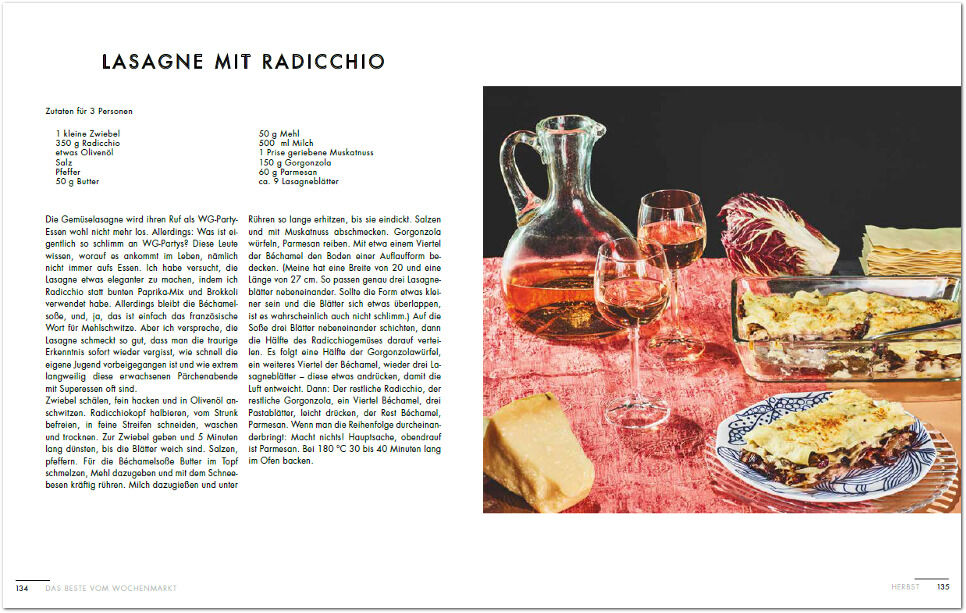 Ein offenes Kochbuch mit einem Rezept für Lasagne mit Radicchio ist abgebildet. Daneben steht ein gedeckter Tisch mit einer Flasche und zwei Gläsern Wein.