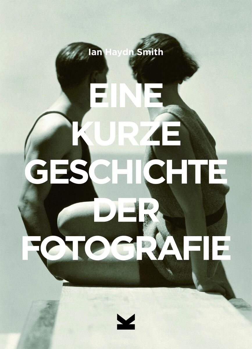 Buchcover von 'Eine kurze Geschichte der Fotografie' von Ian Haydn Smith. Ein Paar in Badeanzügen steht Rücken an Rücken auf einem Steg, blickend in die Ferne. Der Hintergrund zeigt einen unscharfen Horizont und Himmel. Der Titel des Buches ist in Großbuchstaben in Weiß gehalten und steht zentral auf dem Bild.