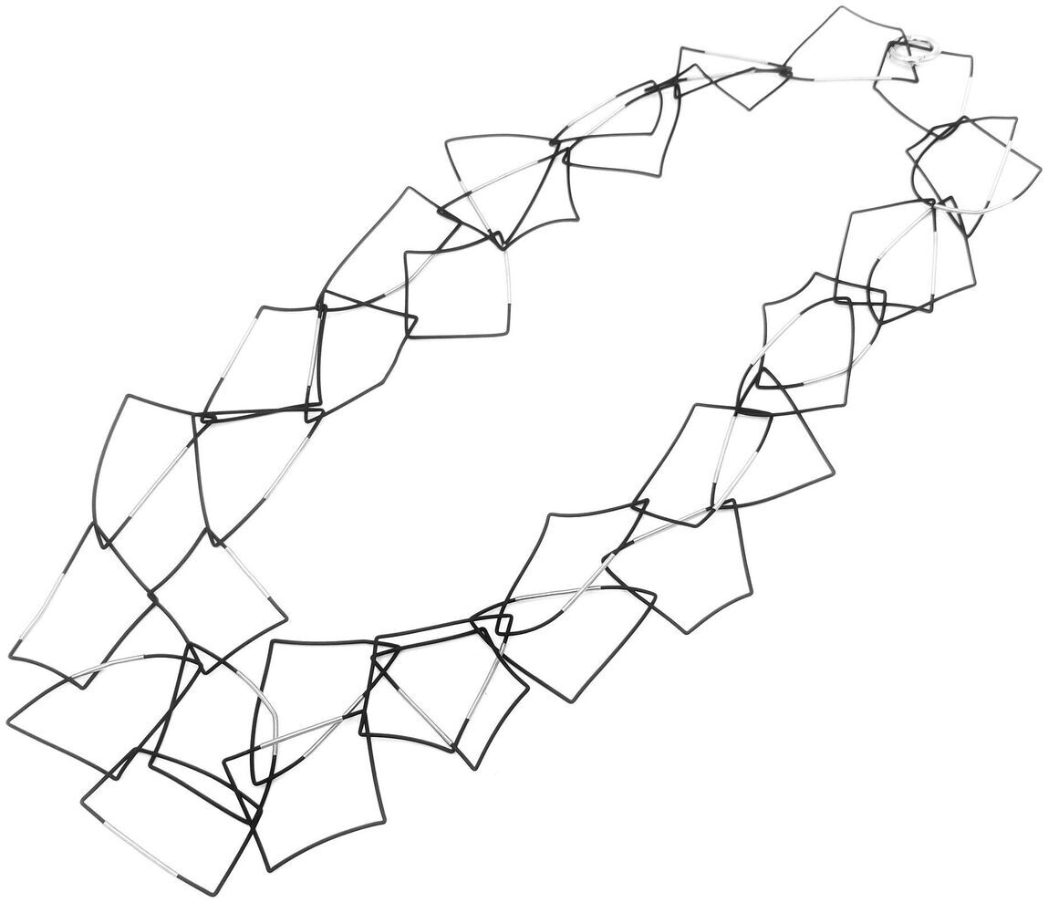 Freigestellte Produktaufnahme der schwarzen Kette »Morphos« von Rosalba Galati auf weißem Grund. Dünne, flexible schwarze PVC-Linien formen einen ovalen, mehrsträngigen Halsschmuck. Entlang der Stränge liegen zahlreiche unregelmäßige, kantige Schlaufen und polygonale Elemente, die eine luftige skulpturale Struktur erzeugen.