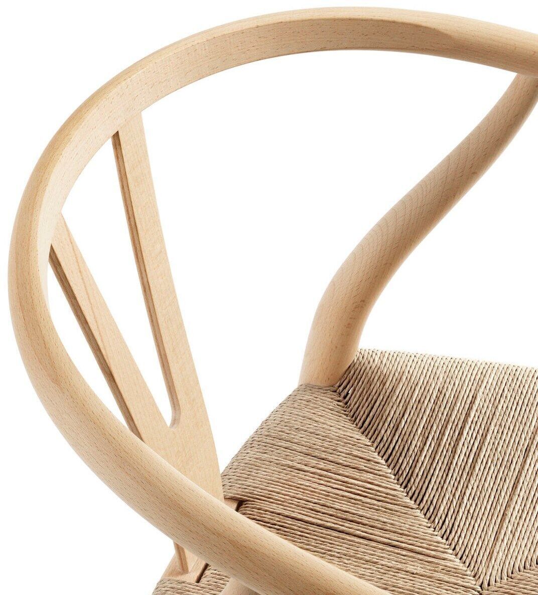 Detailaufnahme der Sitzfläche und Rückenlehne eines Wishbone Chair CH24 von Carl Hansen & Søn. Der Stuhl besteht aus naturbelassenem Holz mit geflochtener Sitzfläche.