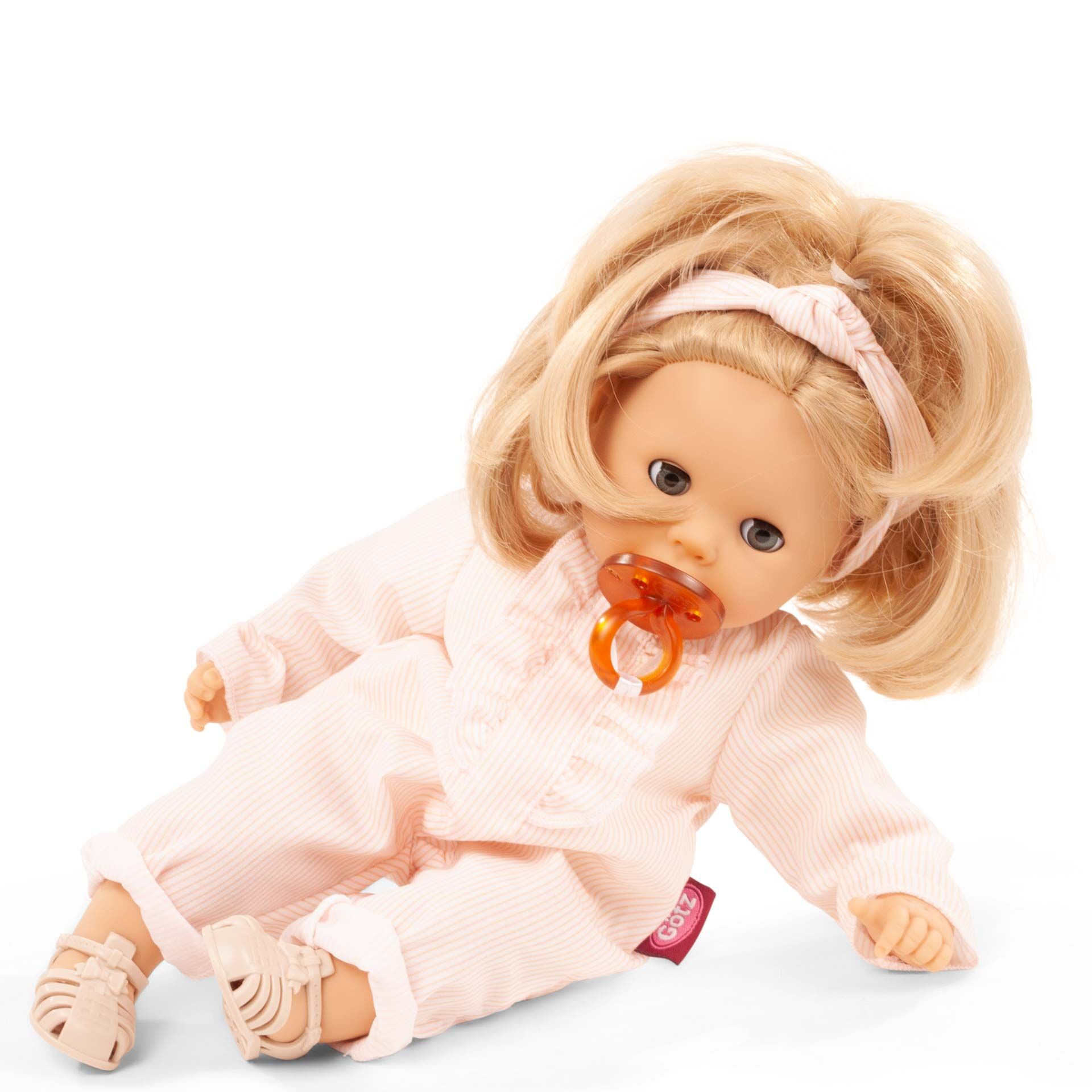 Die Badepuppe »Cosy Aquini Farbspiel« trägt einen rosa Schlafanzug mit Rüschen und rosa Bändchen im Haar. Sie sitzt aufrecht, hält einen orangefarbenen Schnuller im Mund und hat bewegliche Arme und Beine. Die Puppe ist weich gestaltet und eignet sich besonders für kleine Kinder zum Spielen und Kuscheln.