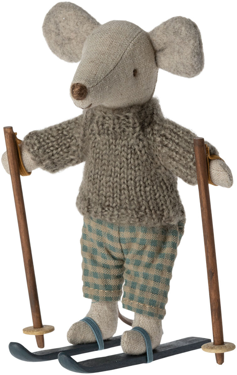 Eine kleine handgemachte Spielzeugmaus, die auf Skiern steht. Die Wintermaus trägt einen gestrickten grauen Pullover und karierte grün-blaue Hosen. Sie hält zwei Skistöcke und trägt Skischuhe, passend zur Winterdekoration.