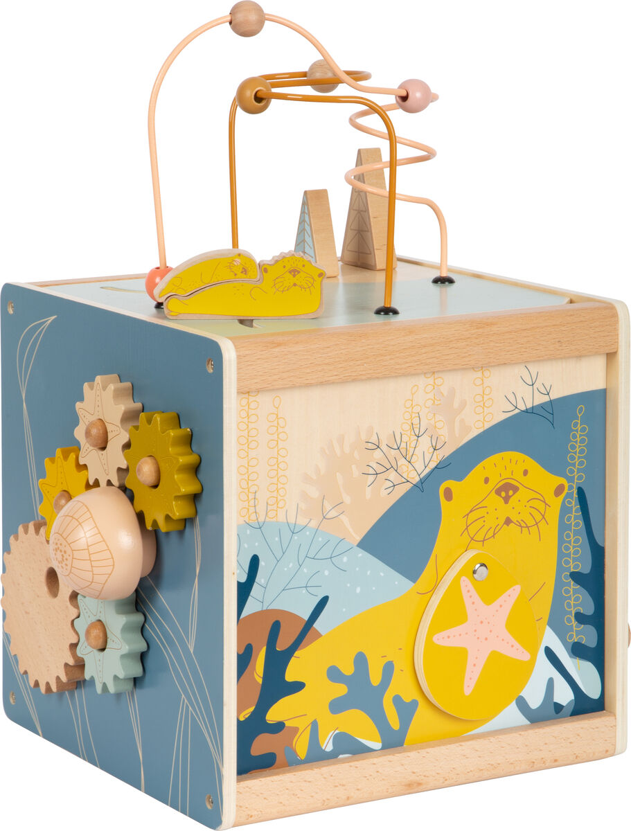 Motorikkiste »Seaside« aus Holz. Das Spielzeug hat eine blaue und gelbe Seite mit Zahnrädern und einem Seehund mit einem Seestern. Oben befinden sich Laufbahnen für Perlen und andere bewegliche Teile.