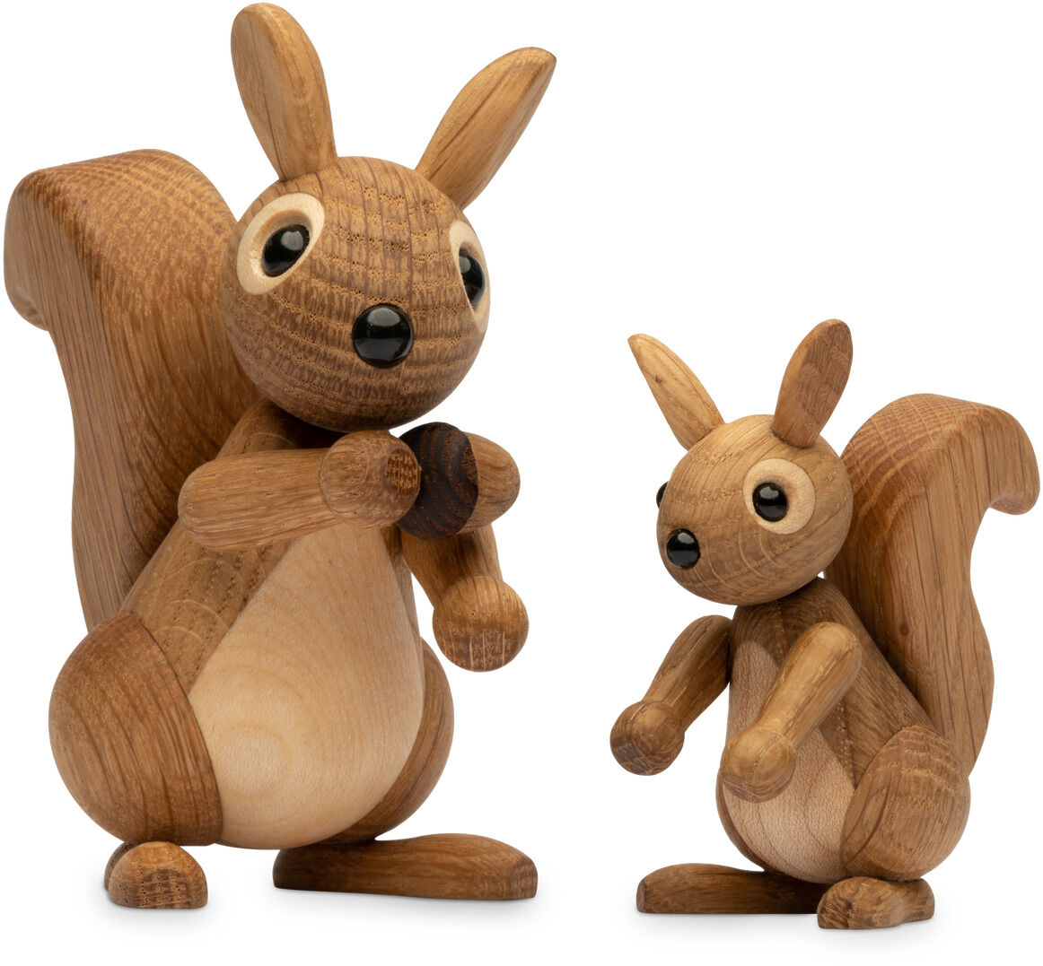 Zwei liebevoll gefertigte Eichhörnchenfiguren aus Holz mit unterschiedlichen Größen, detailreich gearbeitet und aus naturbelassenem Material. Die Figuren stehen aufrecht nebeneinander, ihre großen schwarzen Augen wirken freundlich und einladend. Die Holzstruktur und Maserung sind deutlich sichtbar, wodurch ein natürlicher und handwerklicher Eindruck entsteht.