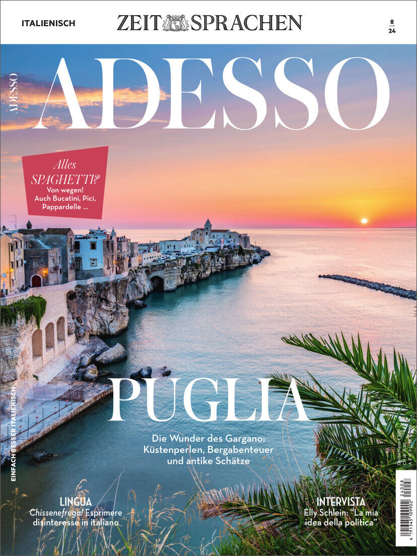 Das Cover des Magazins Adesso Ausgabe 08/2024 zeigt die malerische Küstenlandschaft von Puglia in Italien bei Sonnenuntergang. Im Vordergrund sind Palmen und das Meer zu sehen, während die Küste im Hintergrund von historischen Gebäuden gesäumt ist. Texte auf dem Cover umfassen Themen wie Sprachen, Kultur und Reisen.