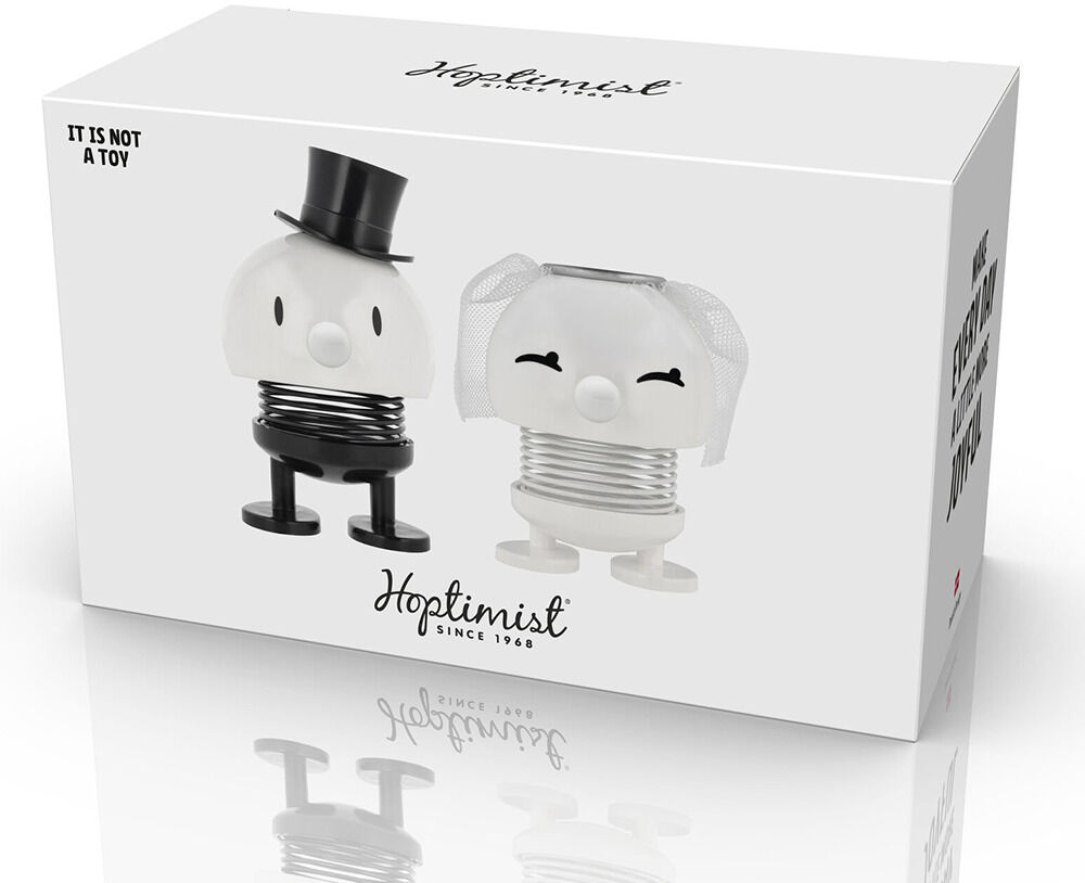 Auf der Verpackung sind zwei charmante Hoptimist-Figuren als Braut und Bräutigam abgebildet: Der Bräutigam trägt Zylinder und schwarze Details, die Braut Schleier und helle Farben. Beide Figuren stehen nebeneinander vor weißem Hintergrund, Logo und Beschriftungen sind vorn zu sehen.