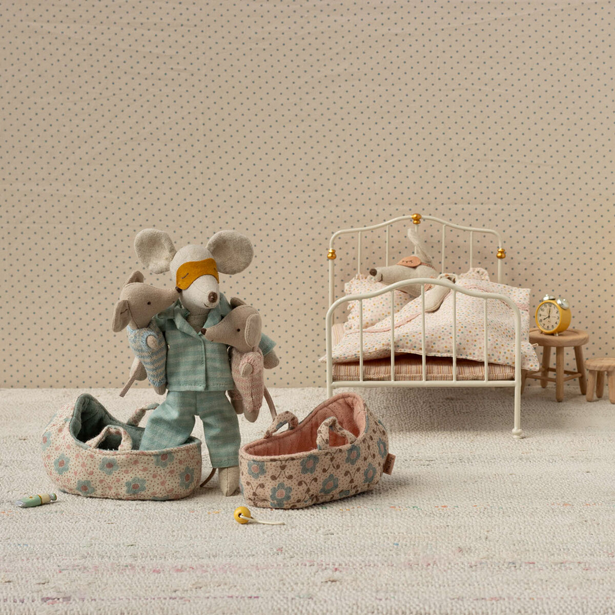 Zwei kleine Stoffmäuse in gemusterten Tragetaschen stehen in einem liebevoll eingerichteten Miniatur-Kinderzimmer mit einem weißen Bett, zarter Bettwäsche, Nachttisch, Wecker und einer kleinen Kommode, geeignet als Spielzeug und Geschenk für Kinder.