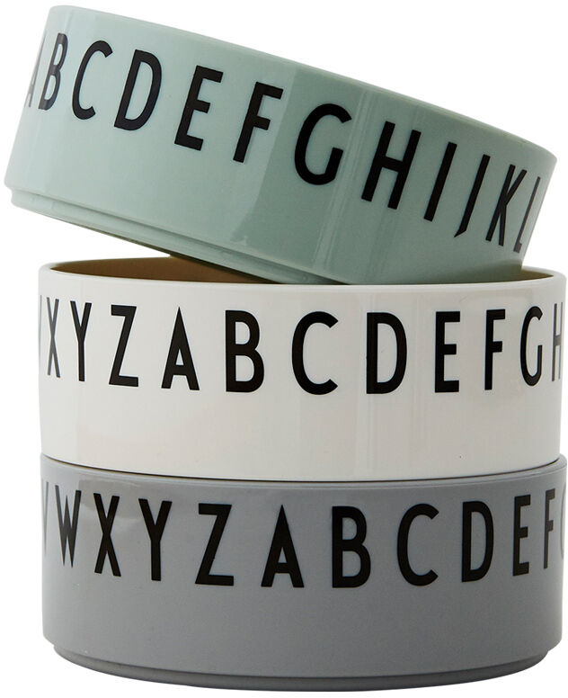 Drei unterschiedlich farbige Schalen mit Buchstabenmotiven in Grün, Weiß und Grau, gestapelt übereinander.