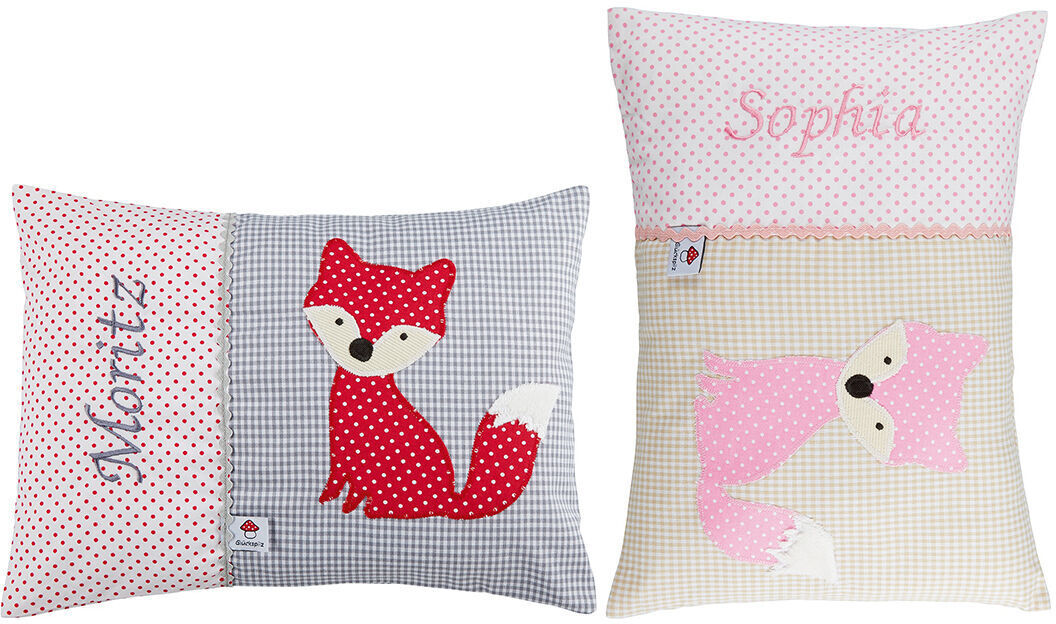 Zwei personalisierte Namenskissen mit Fuchsmotiv in Rosa und Rot. Eines der Kissen hat den Namen Moritz auf einem grauen und weißen gepunkteten Hintergrund mit einem roten Fuchs, das andere hat den Namen Sophia auf einem beigen und rosaroten Patchwork-Hintergrund mit einem rosafarbenen Fuchs.