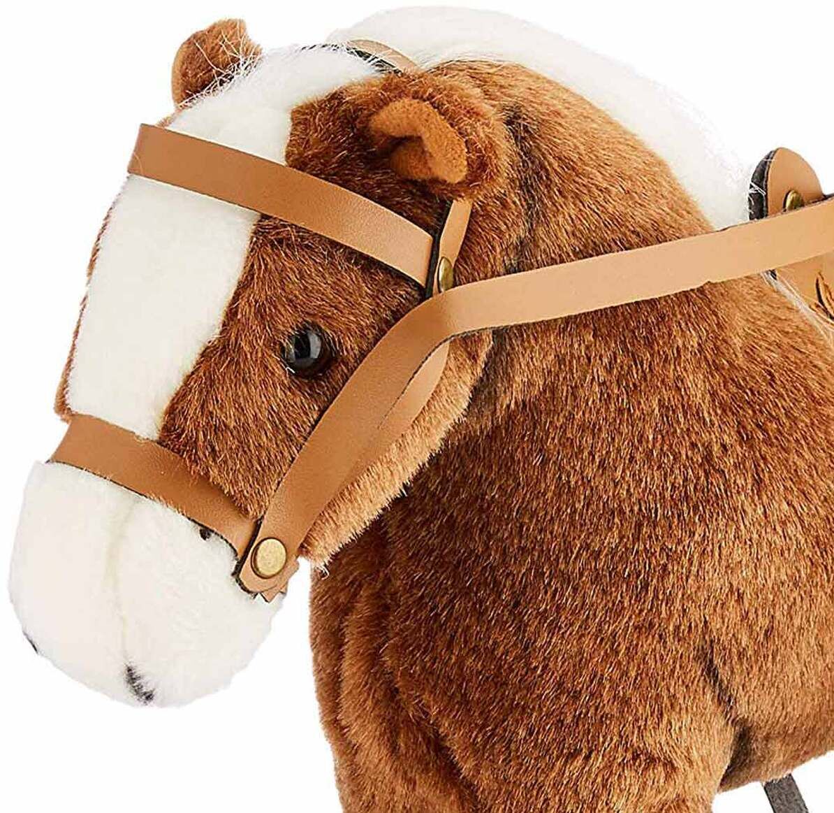 Ein braunes Plüschpony mit weißer Mähne und Schweif sowie weißen Beinpartien. Das Pony trägt einen hellbraunen Sattel und Zaumzeug. Das Stofftier eignet sich als Spielzeug für Kinder und als dekoratives Element im Kinderzimmer.