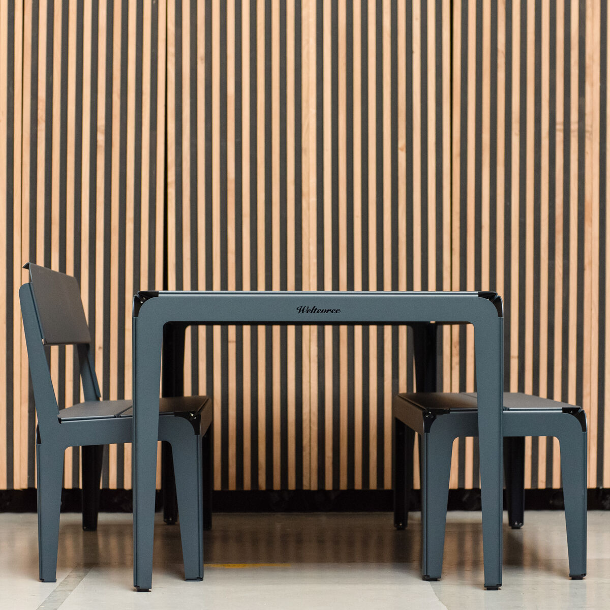 Eine stilvolle, moderne Bank mit einem gebogenen Design, aus dunklem Holz gefertigt. Sie steht vor einem Hintergrund aus ebenfalls gestreiftem Holz und vermittelt ein minimalistisches und elegantes Designgefühl.