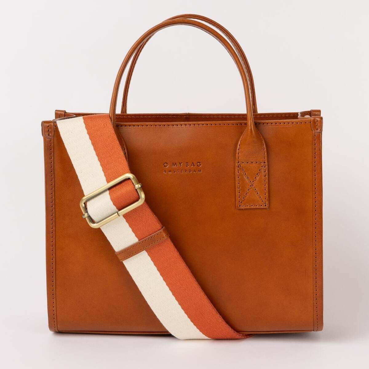 Braune Handtasche aus Lederimitat mit zwei Tragegriffen und einem breiten, verstellbaren Schultergurt in Weiß und Orange, vor hellem Hintergrund stehend.
