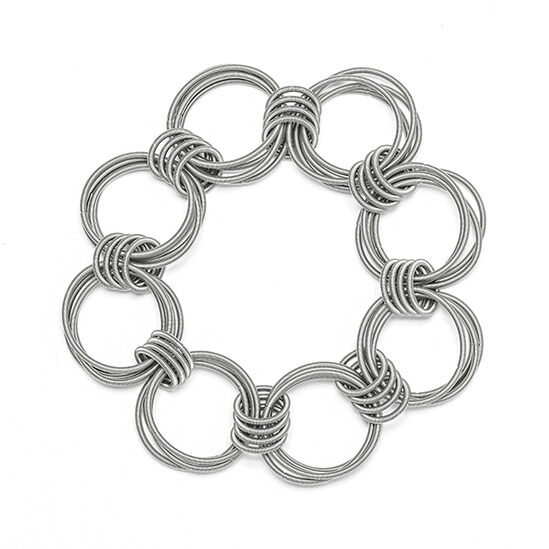 Ein handgemachtes Armband aus silbernen Metallringen, das in einem kreisförmigen Muster gestaltet ist.