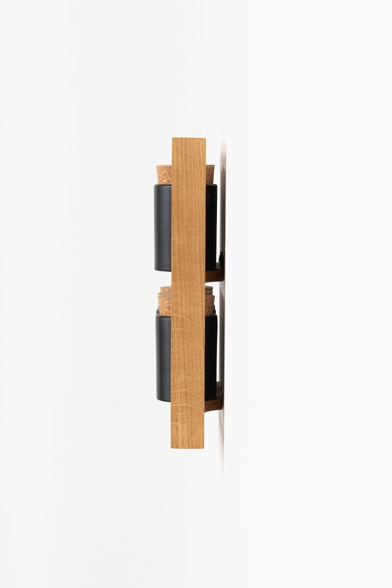 Ein minimalistisches Gewürzregal aus Holz zur Wandmontage mit schwarzen Behältern. Das Regal enthält zwei Schichten für Gewürzgläser. Das Design ist modern und platzsparend.