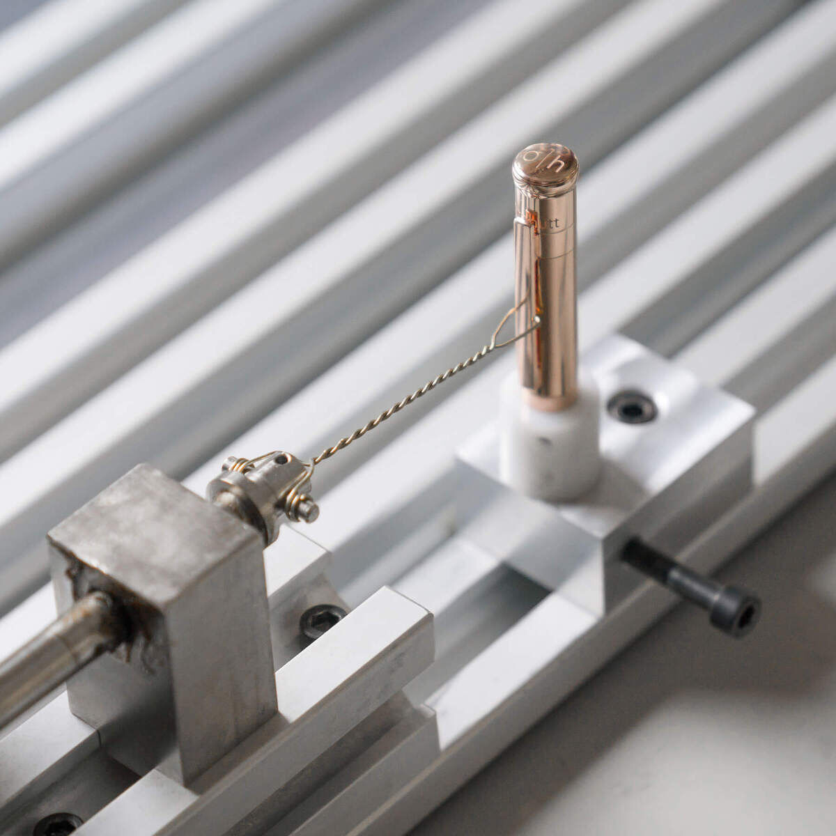 Nahaufnahme eines luxuriösen Kugelschreibers der ZEIT-Sonderedition Design04. Der Stift hat ein rosegoldenes Oberteil und liegt auf einer silbernen, industriellen Plattform, die Präzision und Hochwertigkeit betont.