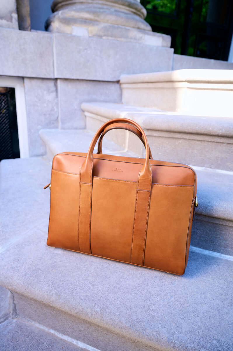 Ledertasche »Harvey« in brauner Farbe, platziert auf einer steinernen Treppe, eleganter und stilvoller Look aus hochwertigem Leder, geeignet für den täglichen Gebrauch, Arbeit oder Reisen.