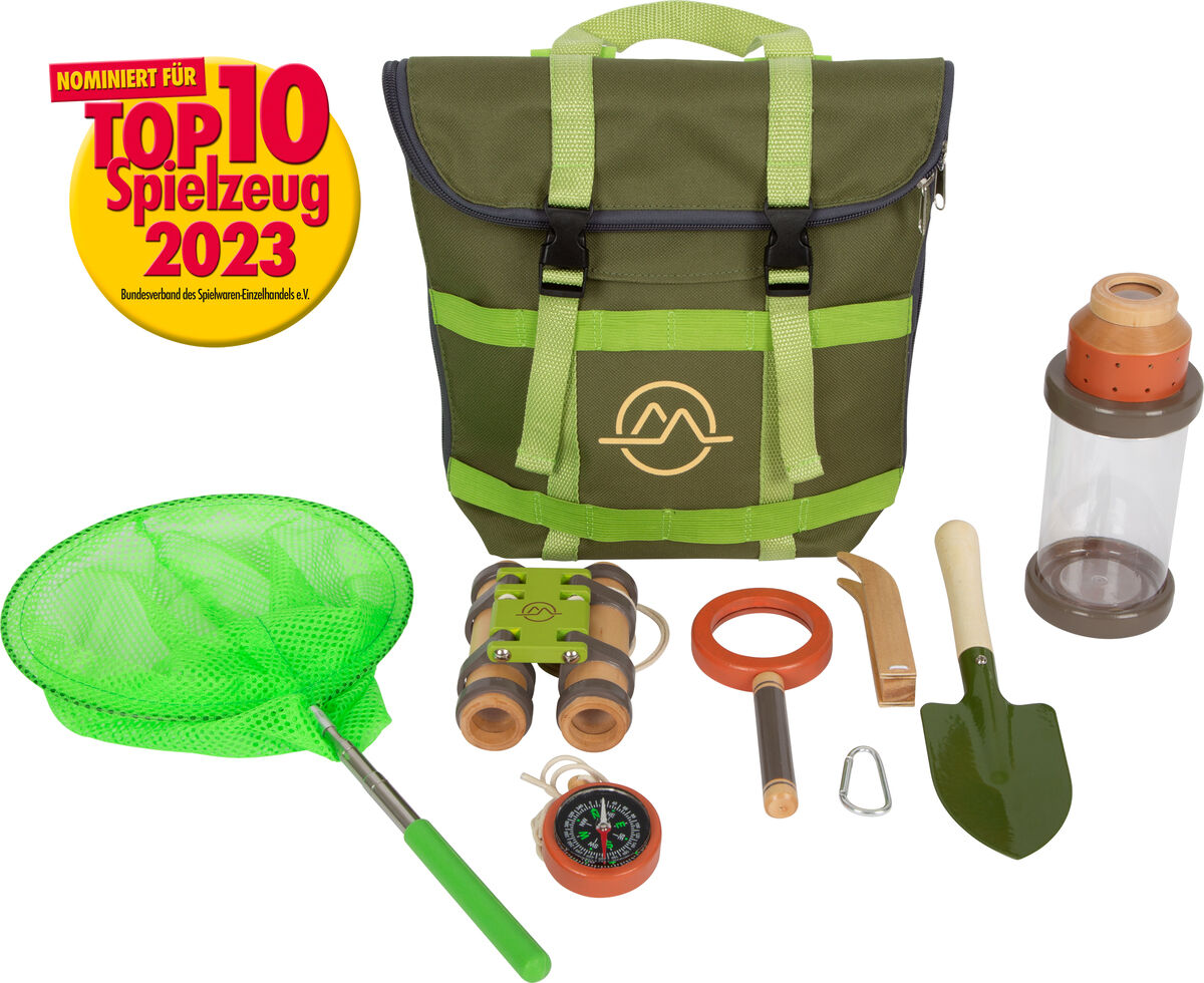 Ein grüner Entdeckerrucksack mit verschiedenen Outdoor-Spielzeugen für Kinder, darunter ein Fernglas, eine Schaufel, ein Insektennetz und weitere Erkundungsgeräte. Der Rucksack ist für Entdeckungsabenteuer in der Natur geeignet und trägt das Logo einer Spielzeugauszeichnung.