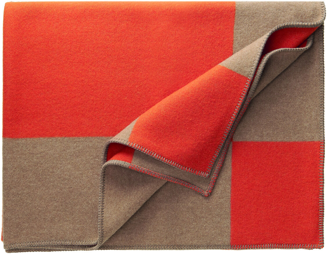 Eine Decke mit dem Namen »Manchester«, die ein rot-braunes Karo-Muster hat. Die Decke ist aufgeschlagen und zeigt die weiche, gemütliche Textur.