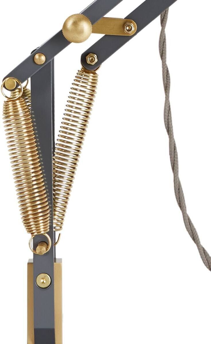 Nahaufnahme der Tischleuchte »Anglepoise Original 1227 Brass Desk Lamp«. Die Leuchte verfügt über eine verstellbare Struktur aus schwarzem Metall mit goldenen Akzenten und einem spiralförmigen Kabel.