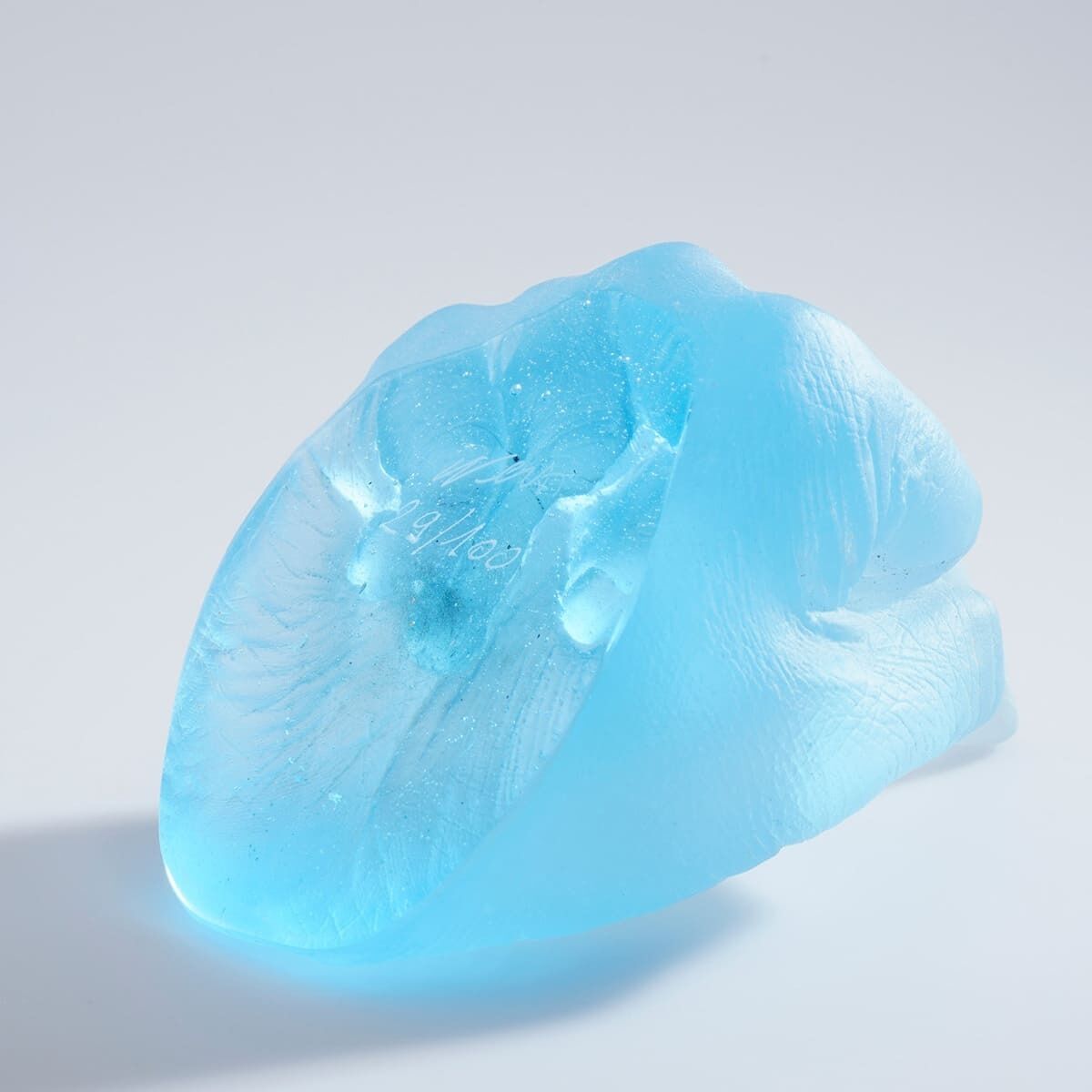 Eine Skulptur von Ai Weiwei mit dem Titel »Study of Perspective in Glass«. Die Skulptur besteht aus hellblauem Glas und zeigt eine abstrahierte Form.