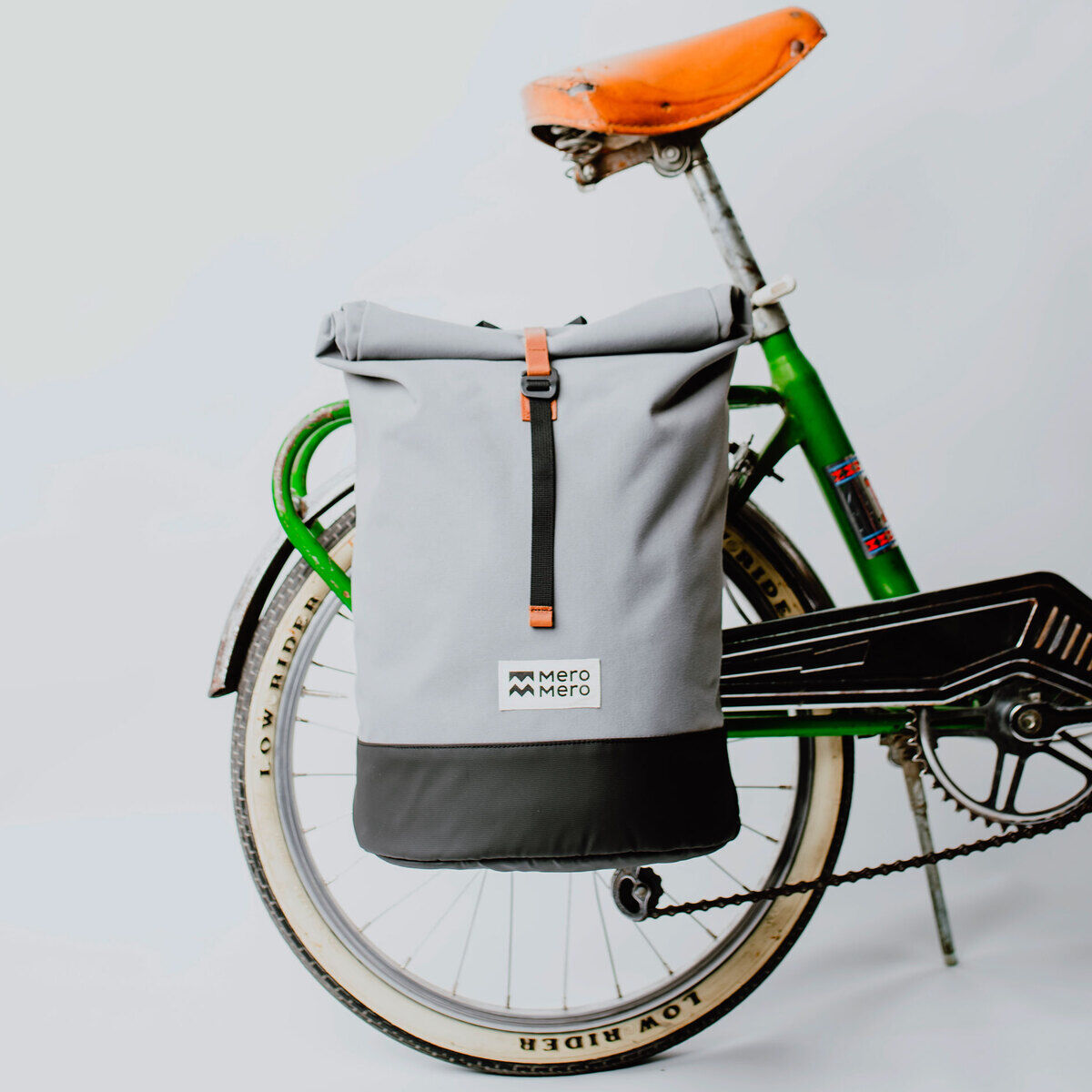 Fahrradtasche/Rucksack »Annecy« in grau und schwarz, befestigt an einem grünen Fahrrad mit braunem Sattel.