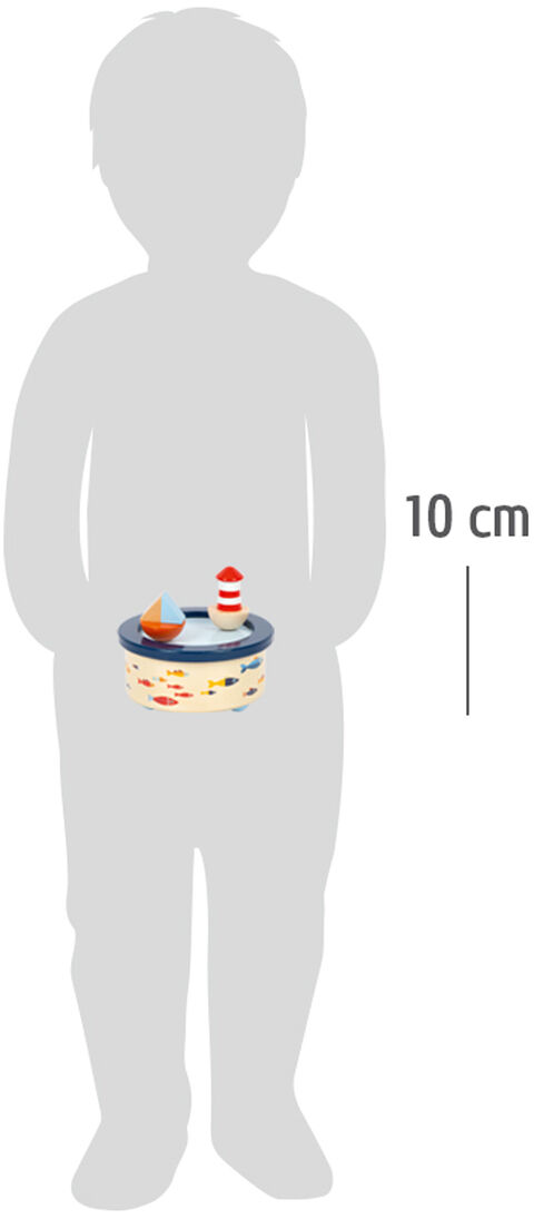 Ein Kind hält eine Spieluhr in Form eines Ozeanszenarios mit einem Boot und einem Leuchtturm. Die Spieluhr ist etwa 10 cm groß und farblich in Blau, Weiß und Rot gestaltet.
