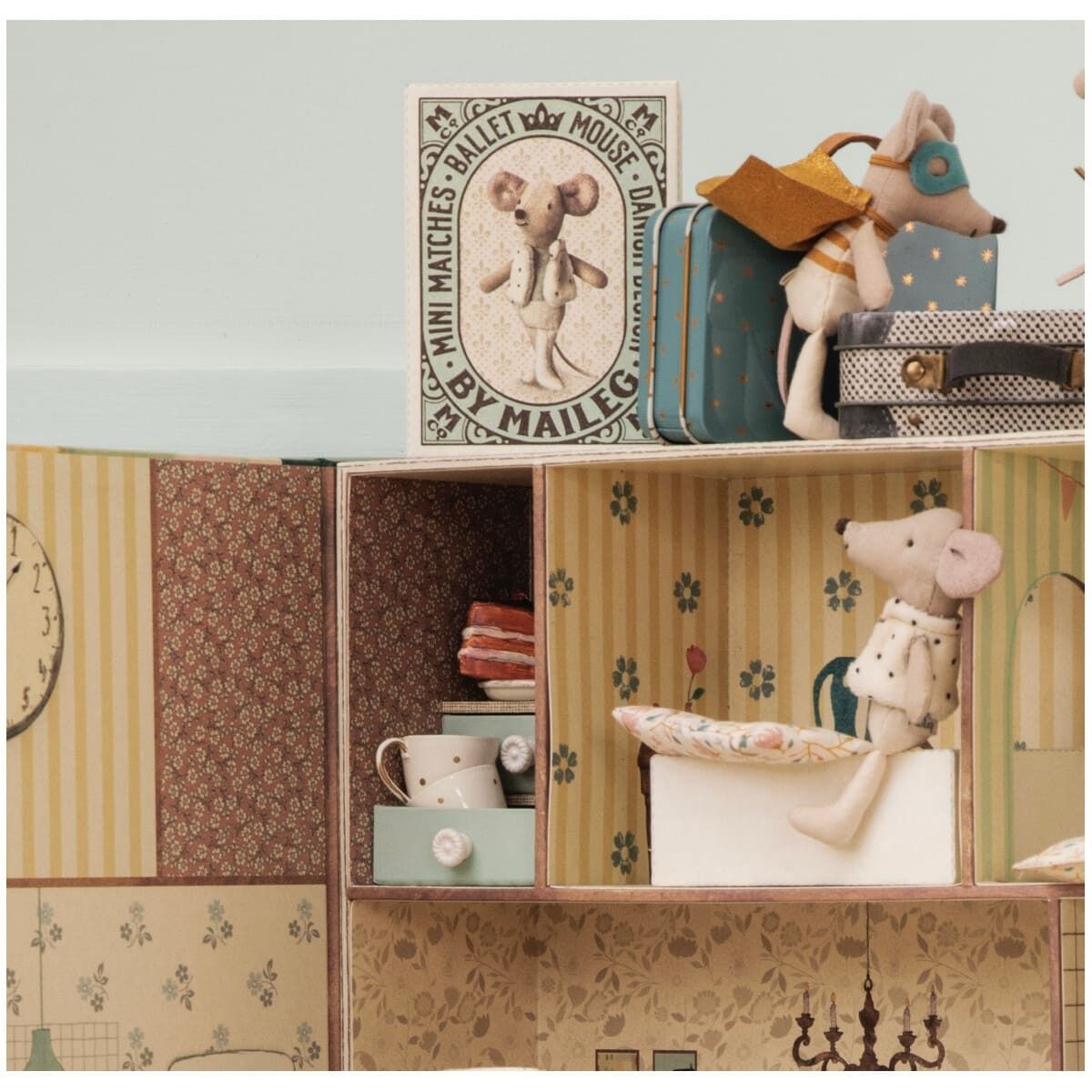 Eine handgefertigte Superheldmaus sitzt in einer offenen Streichholzschachtel, umgeben von dekorierten Regalen und Miniaturgegenständen. Das Setting ist ein nostalgisches Kinderzimmer mit sanften Farben.