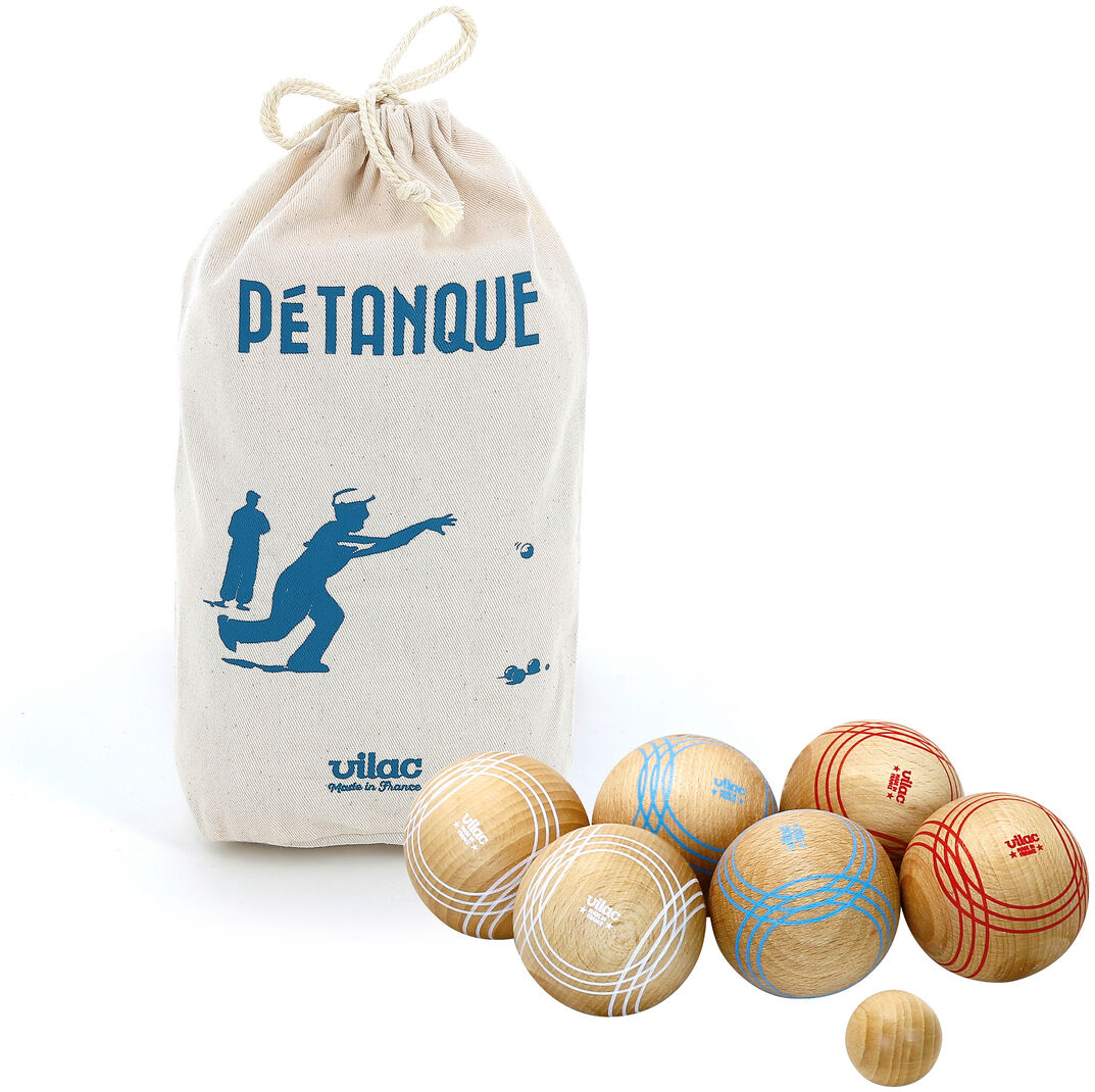 Boule-Spiel mit hellen Holzkugeln, verziert mit roten und blauen Linien, und einer beigen Tasche mit dem Aufdruck 'Petanque' und einer Silhouette spielender Personen auf der Vorderseite.