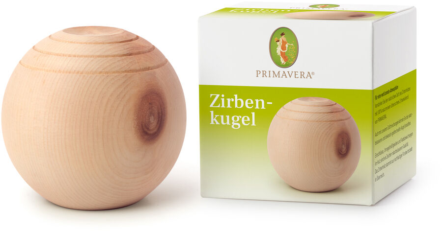 Aroma Zirbenkugel und Verpackung. Die Holzkugel ist naturbelassen, glatt und rund. Die Verpackung ist weiß mit grünen Elementen, darauf steht 'Zirbenkugel' und das Logo von Primavera.