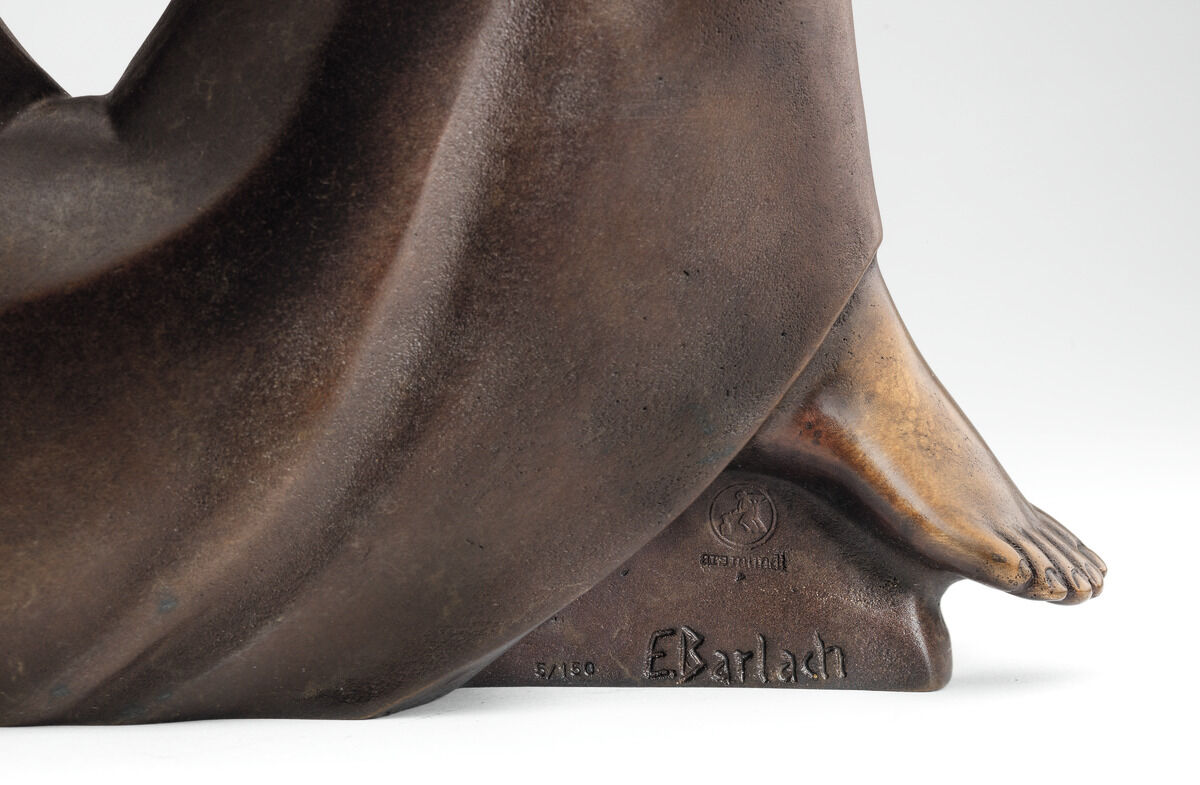 Nahaufnahme einer Bronzeskulptur von Ernst Barlach aus dem Jahr 1928 mit dem Titel 'Der singende Mann'. Das Bild zeigt den unteren Teil des Kunstwerks, einschließlich eines Fußes und eines Teils des Sockels, auf dem die Signatur 'Barlach' erkennbar ist.