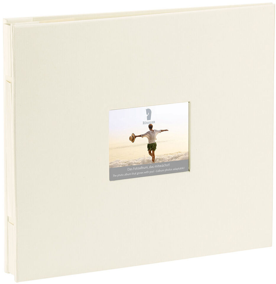 Ein cremefarbenes Fotoalbum mit einem kleinen quadratischen Fenster auf dem Einband. Das Fenster zeigt ein Bild von einer Person, die an einem sonnigen Tag nach oben springt. Das Album ist schlicht und elegant gestaltet.