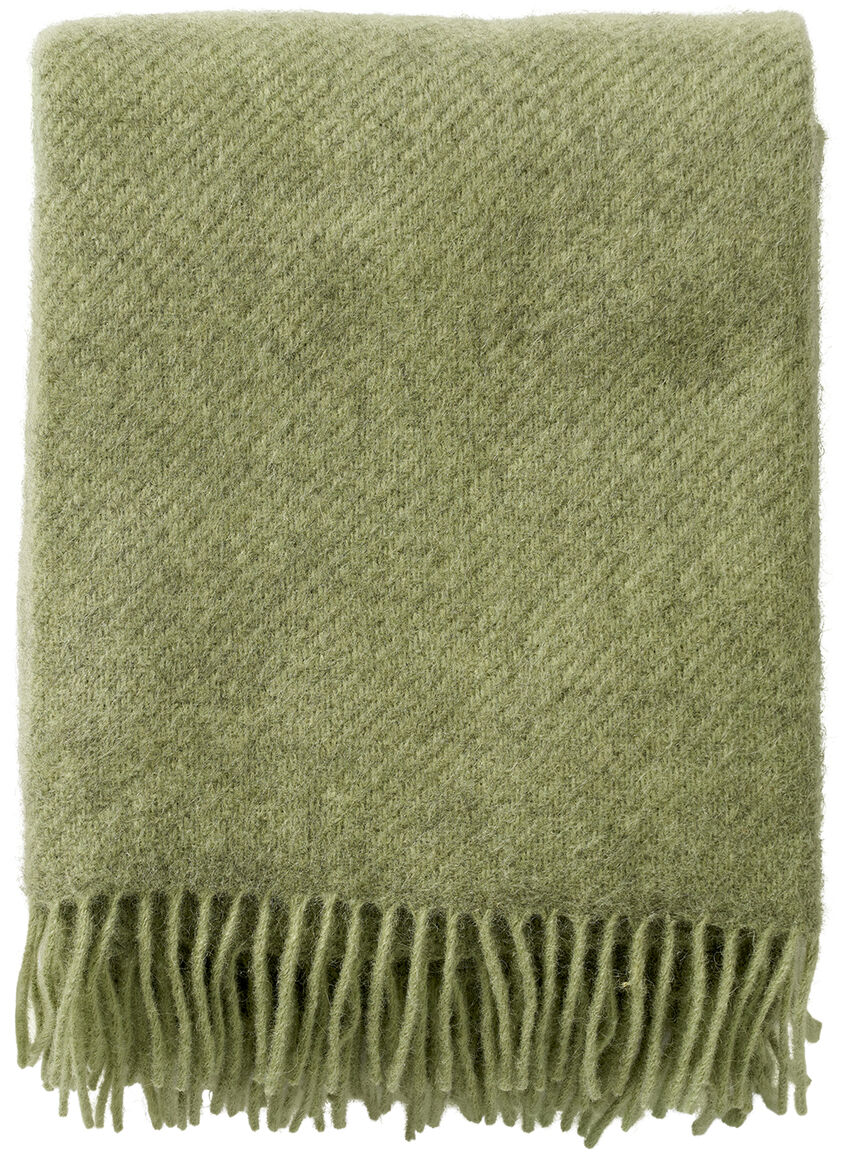 Eine Decke in Grün mit Fransen an den Enden.