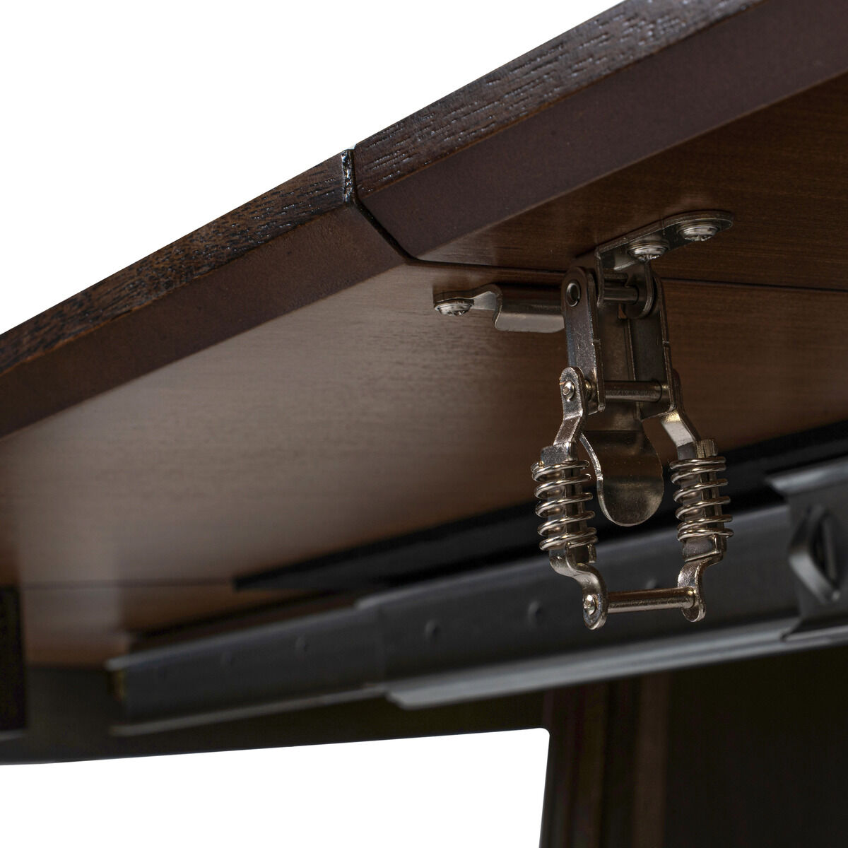 Detailansicht der Unterseite des Dining-Tischs »Oria 120cm« von bene living in Smoked Braun. Sichtbar ist die solide Ausziehmechanik aus Metall unter der dunkelbraunen Tischplatte. Die Materialien und Bauweise ermöglichen ein Ausziehen der Tischfläche.