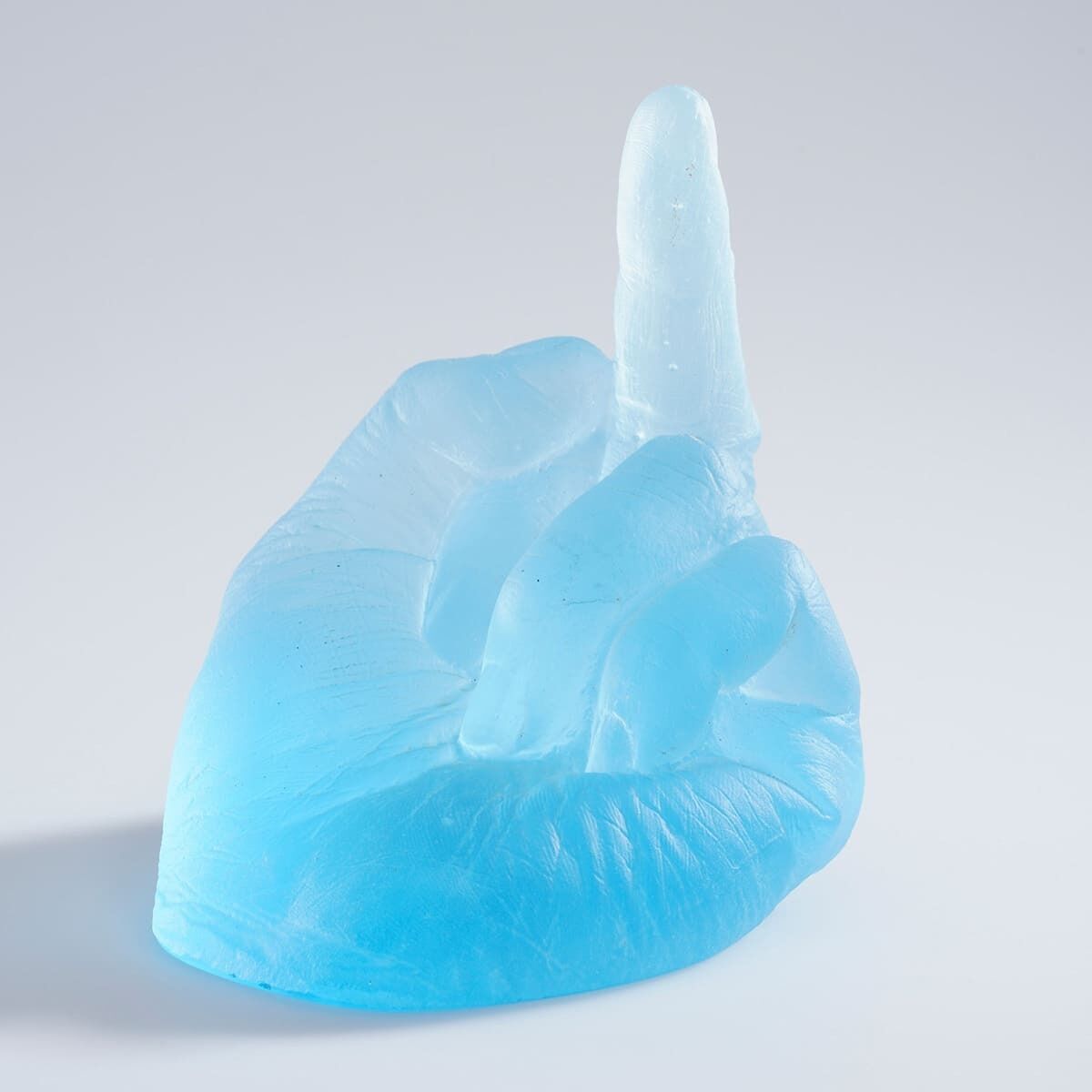Eine aus blauem und weißem Glas geformte Skulptur, die eine Hand darstellt, bei der der Mittelfinger ausgestreckt ist, entworfen von Ai Weiwei, genannt »Study of Perspective in Glass«.