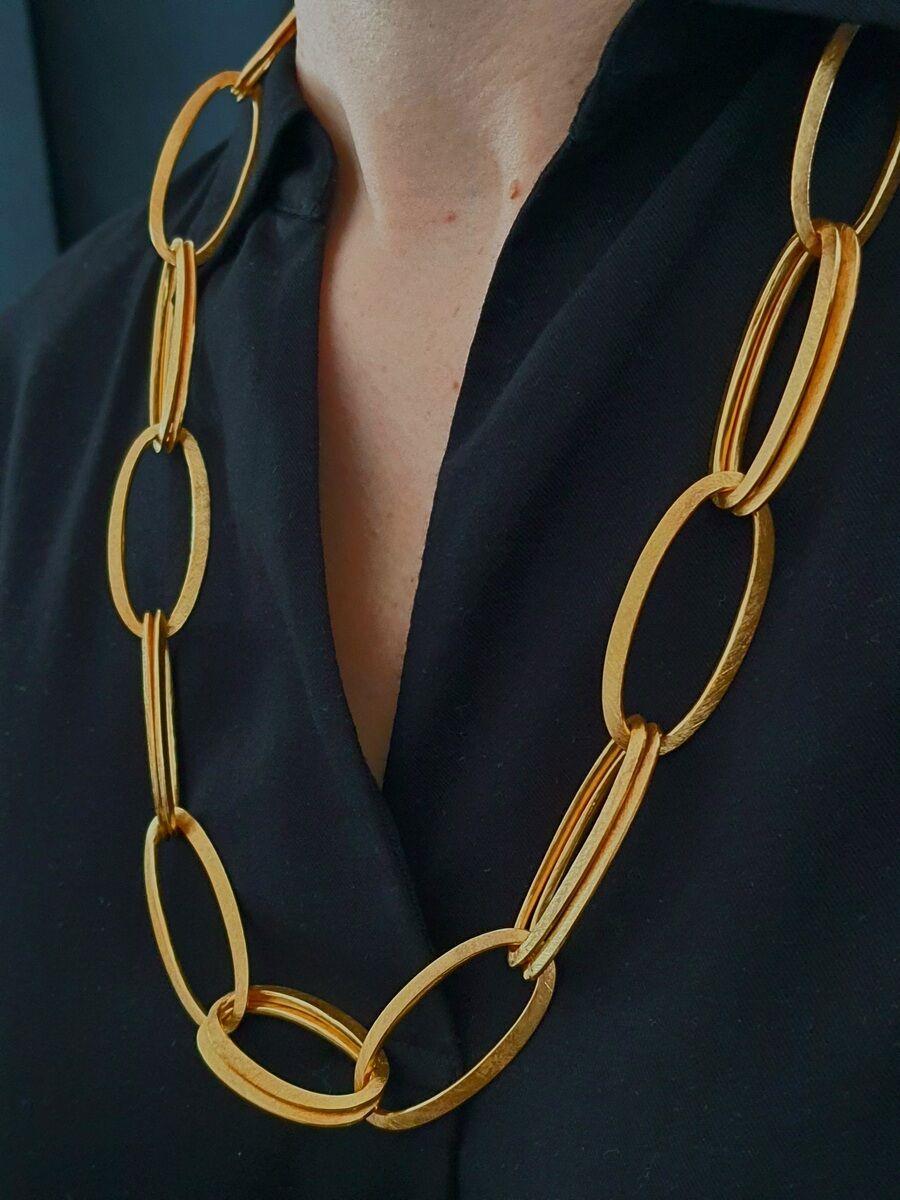 Die HML-Collier »GRACE« ist eine goldene Statement-Halskette mit großen, ovalen Gliedern, die einen eleganten und modernen Eindruck vermittelt und gut zu schwarzer Kleidung passt.