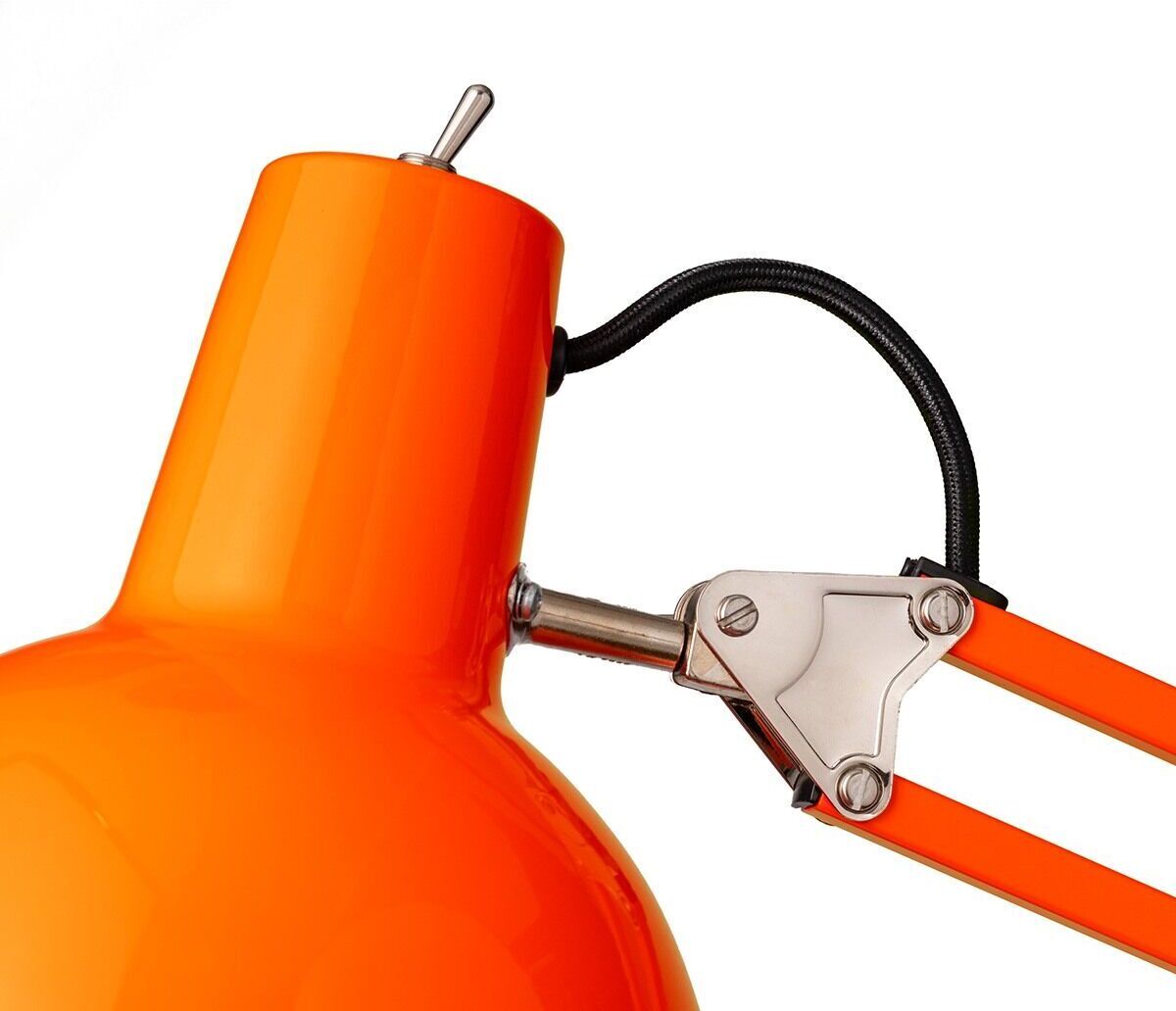 Nahaufnahme einer Tischleuchte »Federzug« mit Klemmfuß in leuchtendem Orange. Die Lampe hat eine moderne Konstruktion mit schwarzen und silbernen Elementen für ein industrielles Design.