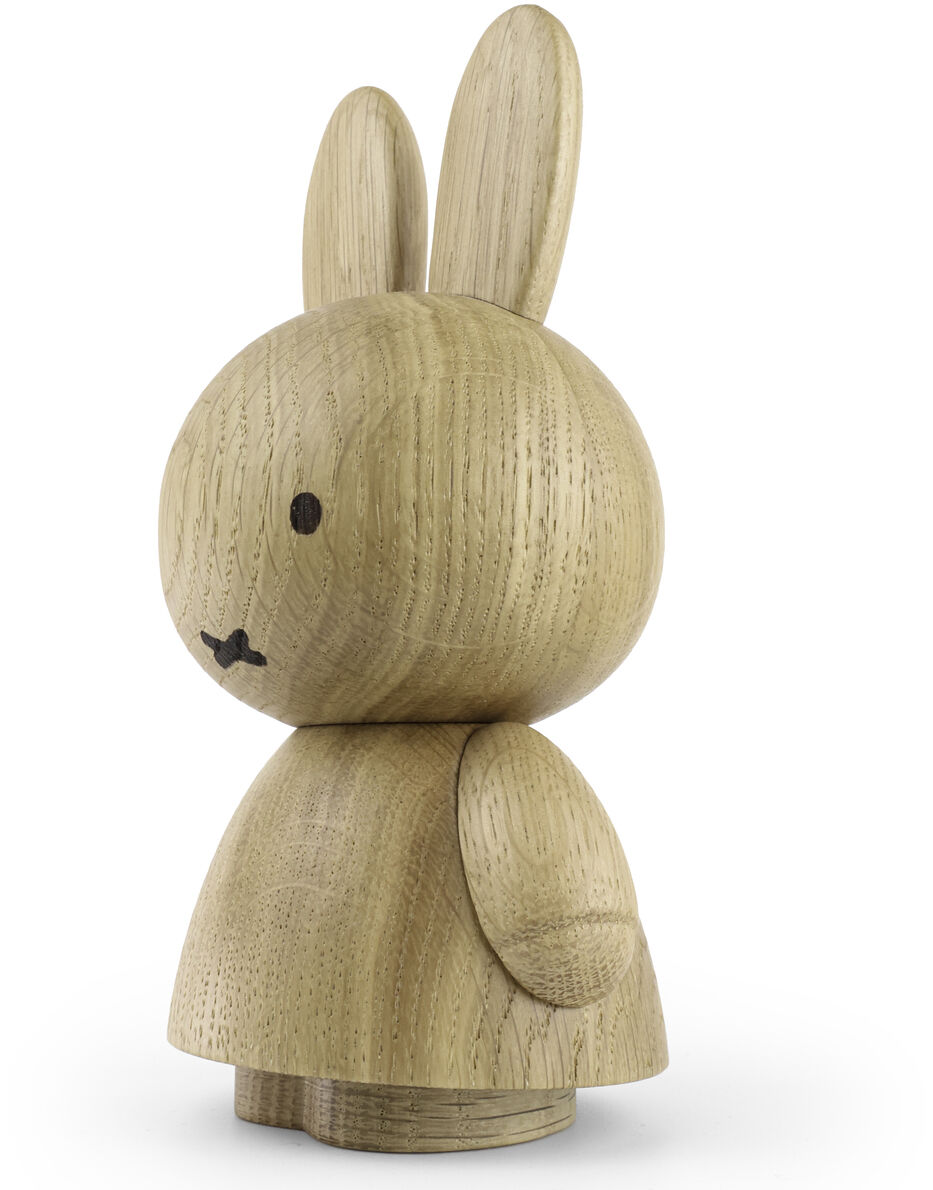 Die Abbildung zeigt eine detailliert gearbeitete Holzfigur des Charakters Miffy, gefertigt aus hellem, naturbelassenem Holz. Die Figur hat zwei große Ohren, einen runden Kopf mit schwarzen, minimalistischen Details für Gesicht und Mund, sowie einen schlichten, abgerundeten Körper. Sie steht aufrecht auf einer weißen Fläche.