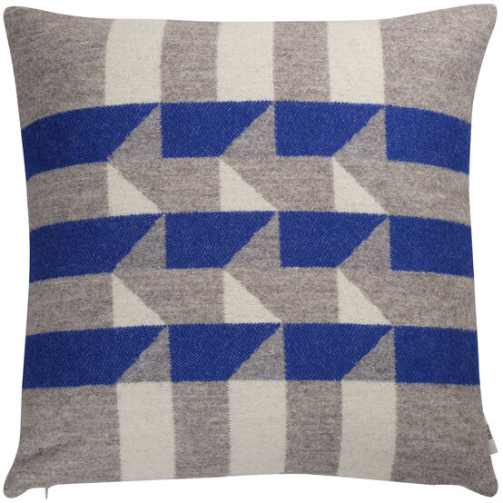Ein quadratisches, geometrisch gemustertes Kissen mit blauen, grauen und weißen Streifen. Das Kissen trägt den Namen »KVAM«.