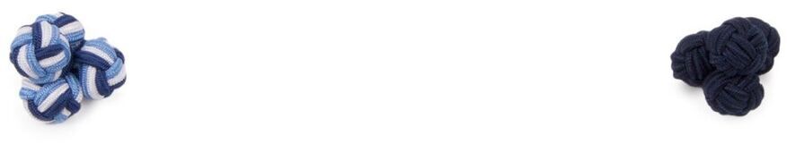 Zwei Paar Stoff-Manschettenknöpfe in Knotenform. Ein Paar ist blau-weiß gestreift, das andere ist komplett schwarz. Beide liegen auf einer weißen Oberfläche.