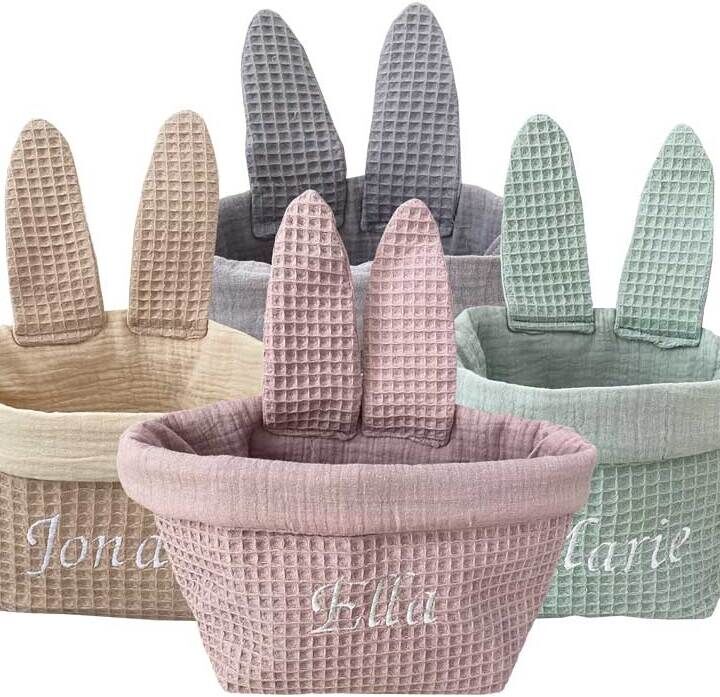 Ein Satz von fünf Osterkörbchen in Form von Hasenohren mit Namensstickerei in Beige, Grau, Rosa und Mintgrün. Ideal als Osterdekoration oder Geschenk für Kinder.