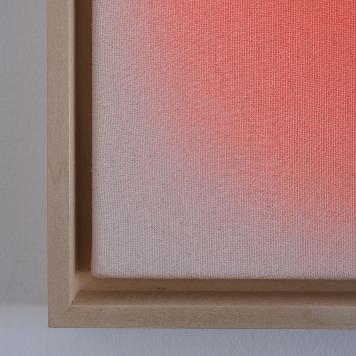 Quadratisches Bild im Format 30x30 cm mit sanftem apricotfarbenen bis rosafarbenem Farbverlauf auf einer strukturierten Leinwand, eingefasst in einen hellen Holzrahmen, minimalistisch und modern gestaltet, geeignet als stilvolle Wanddekoration.