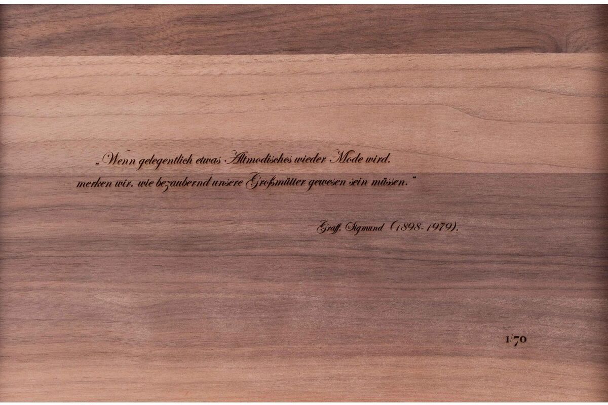 Ein ZEIT-Accessoire-Set mit einer Holzplatte und einem eingravierten Zitat von Gustav Klimt (1862-1918). Die Platte zeigt eine natürliche Holzmaserung in Brauntönen und Beige, mit einem dezenten, handgefertigten Design. Eignet sich ideal als dekoratives Element oder Geschenk für verschiedene Anlässe.