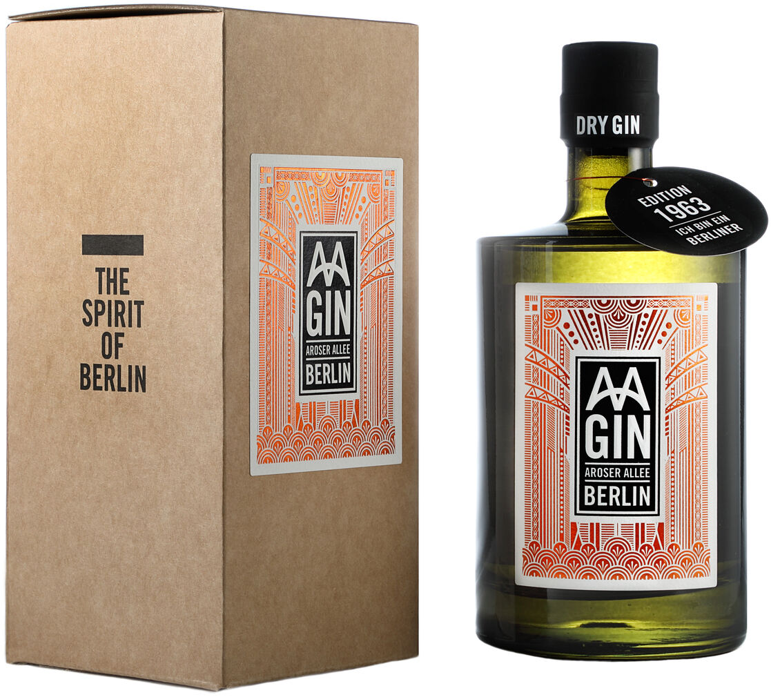 Eine Flasche 'AAGIN' Edition 1963 im Geschenkkarton. Die Flasche ist mit einem orange-weißen Etikett dekoriert, auf dem 'AAGIN Rosser Allee Berlin' steht. Daneben befindet sich ein brauner Geschenkkarton mit der Aufschrift 'The Spirit of Berlin'.