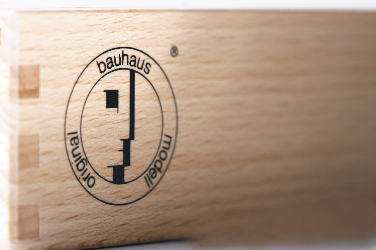 Holzkiste mit dem Aufdruck 'Bauhaus Modell Original' von Naef, was für Schachfiguren steht.