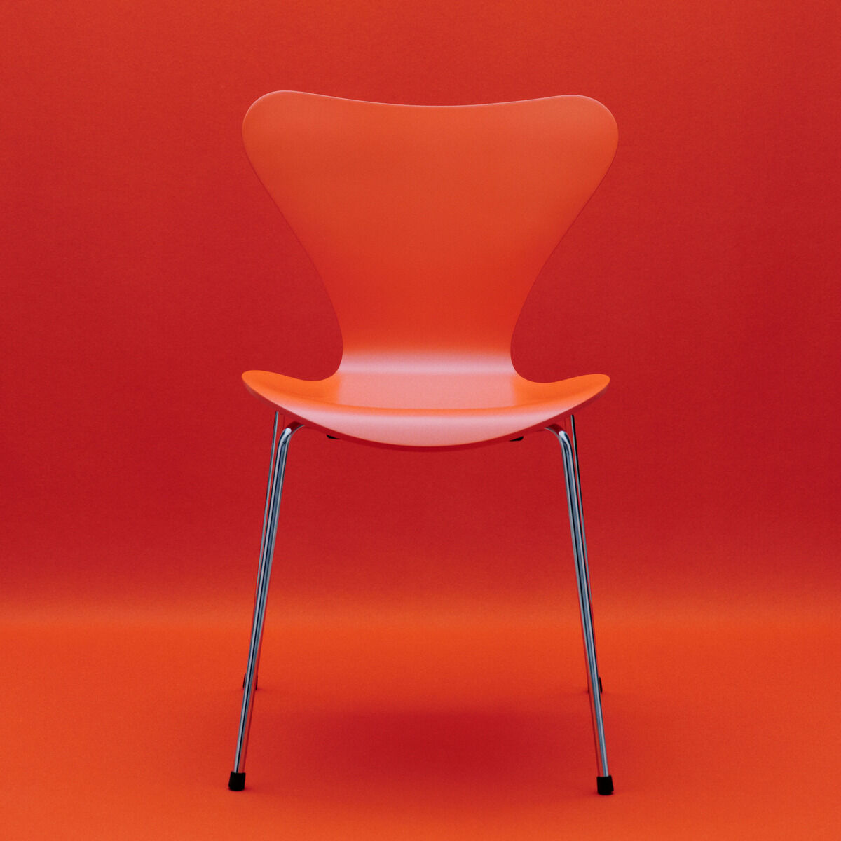 Ein orangefarbener Designstuhl der Serie 7 von Fritz Hansen, Edition Verner Panton, steht mittig vor einfarbig orangefarbenem Hintergrund. Die geschwungene Sitzschale besteht aus lackiertem Buchenfurnier, das Gestell aus filigranen, silbernen Stahlrohrbeinen.