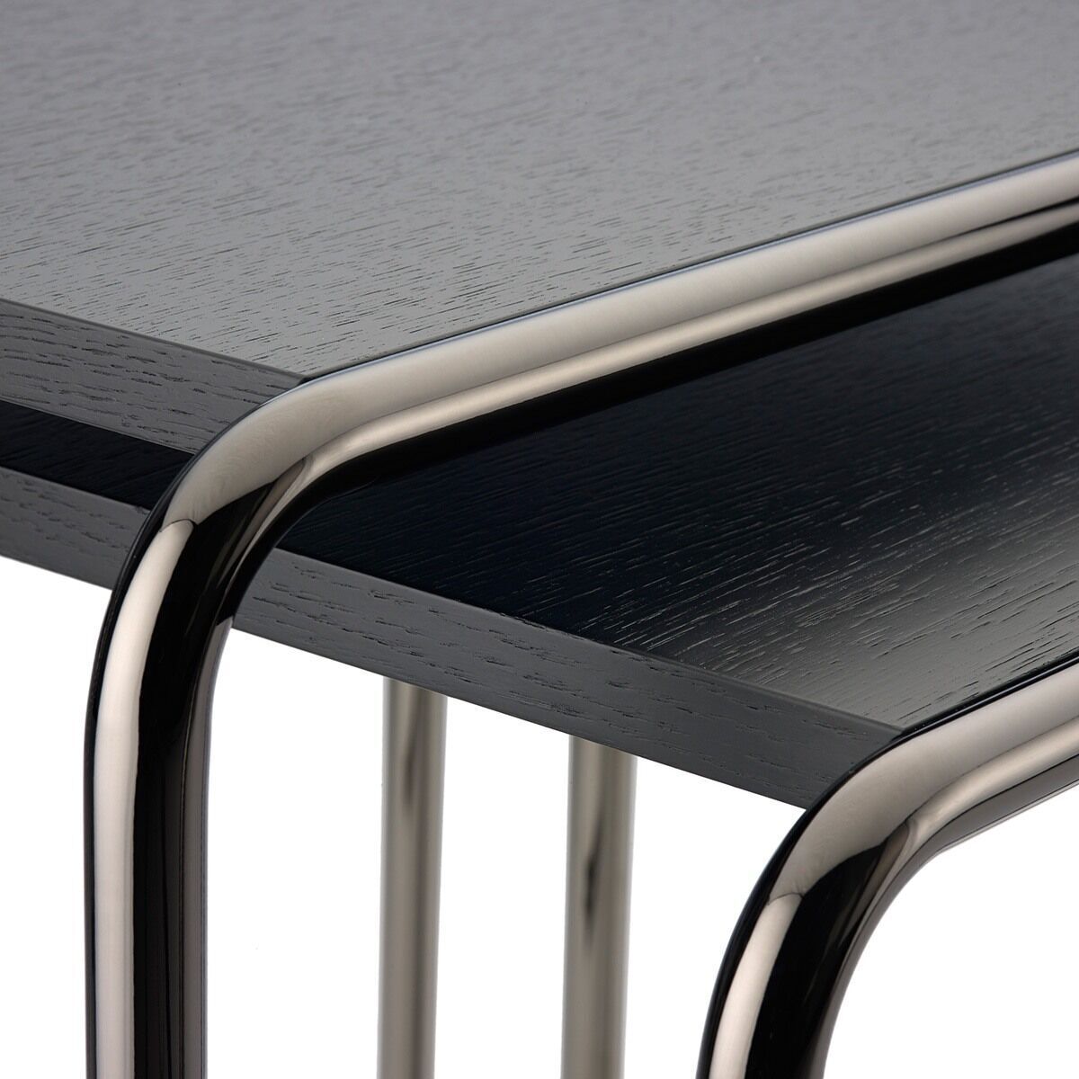Nahaufnahme eines modernen Beistelltisches der ZEIT-Sonderedition B9a/b von Thonet. Der Tisch hat eine schwarze, hölzerne Oberfläche und ein schlankes, silbernes Stahlrahmen-Design.