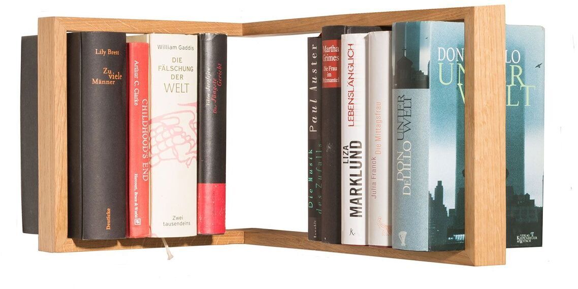 Das Regal »b-eck« ist ein modernes Wandregal aus Holz, das eine Auswahl an Büchern in verschiedenen Farben präsentiert. Es hat ein einzigartiges, modulares Design, das in Innenräumen wie Wohnzimmern oder Büros stilvoll zur Geltung kommt.